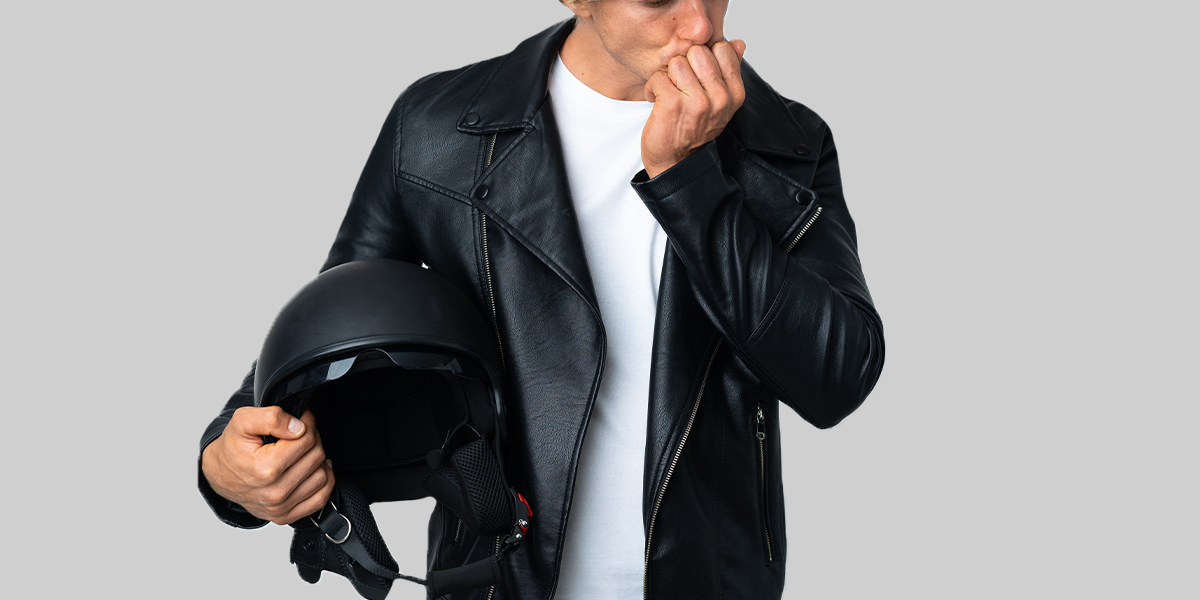 A man sniffing his sleeves for leather jacket